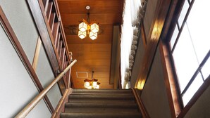 Una escalera de madera con barandilla, techo de madera y una ventana con vistas.