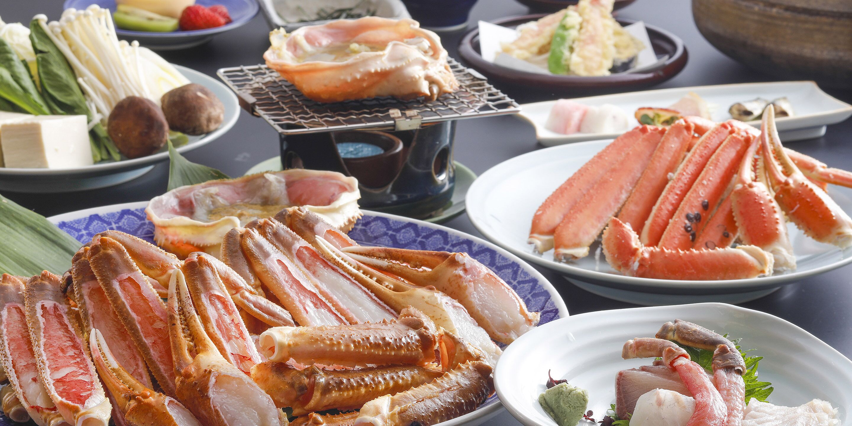 A variety of seafood dishes, including crab legs and other seafood, arranged on plates.