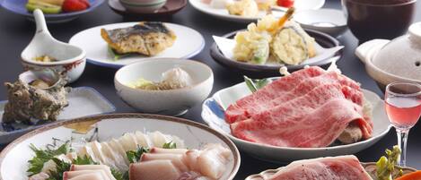 Una variedad de platos, incluyendo sashimi, sushi y otras especialidades de la cocina japonesa, dispuestos sobre una mesa.