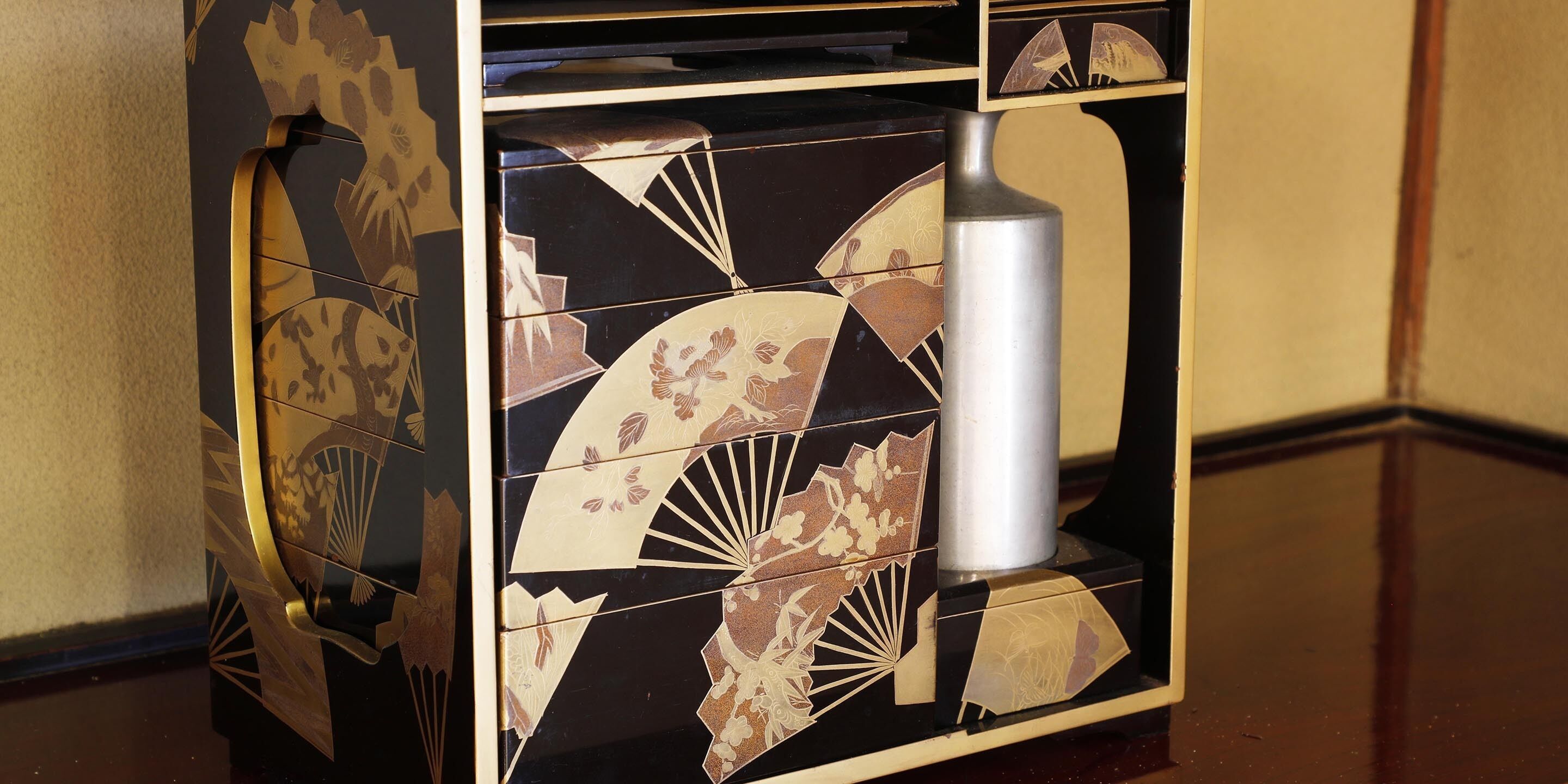 A corner of a room with a decorative cabinet featuring geometric and floral patterns.