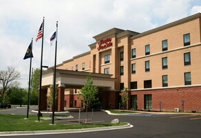 Un hotel de fachada de ladrillo, con múltiples ventanas y un letrero que indica que es un Hampton Inn & Suites.