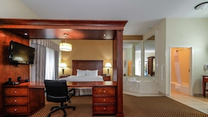 A hotel room with a large bed, a desk with drawers, a chair, a television, and a bathroom with a bathtub and shower. - Hampton Inn & Suites Detroit/Chesterfield Township (New Baltimore)