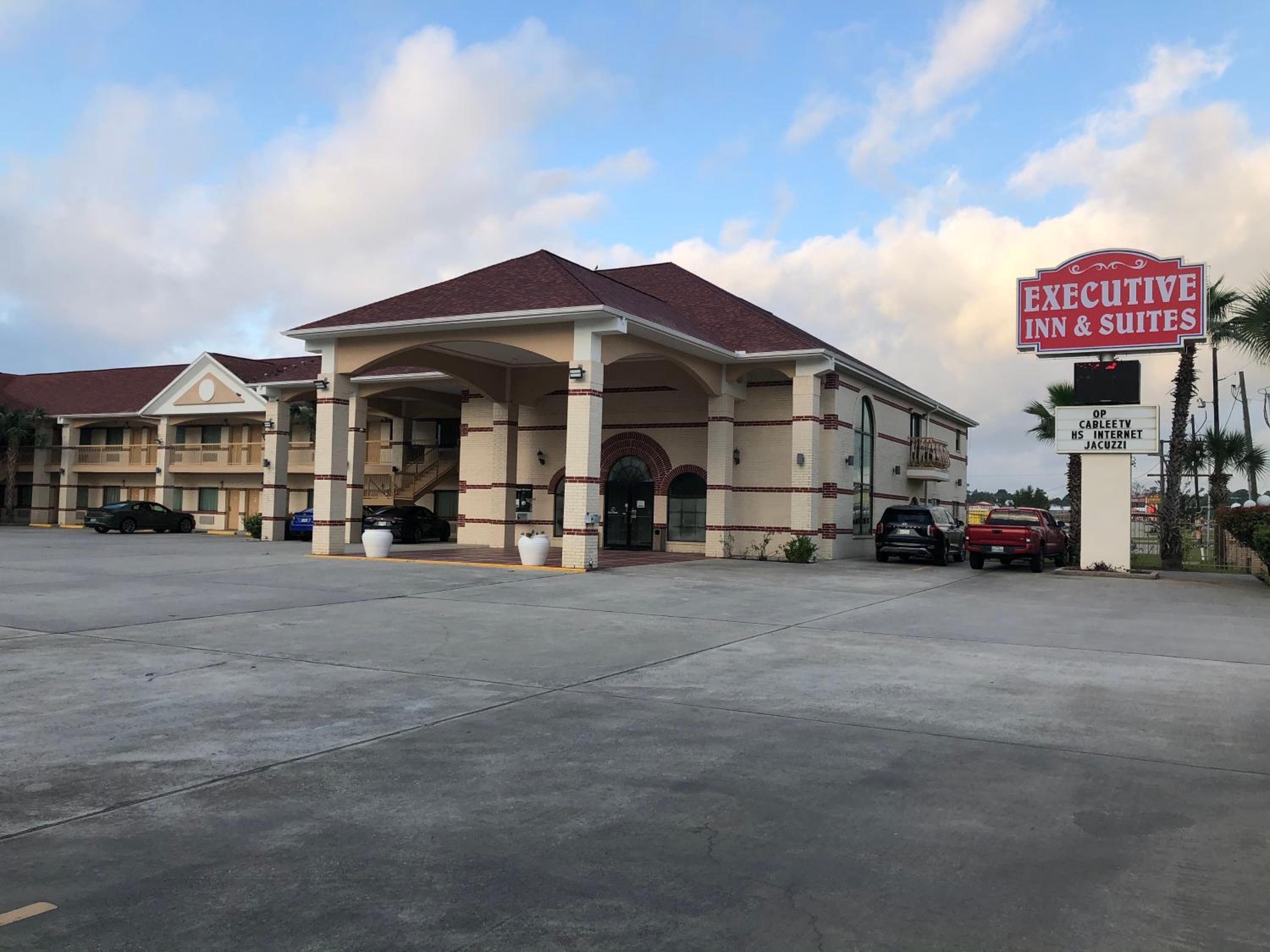Un hotel con tetto rosso e pareti beige, caratterizzato da un ingresso con portico.