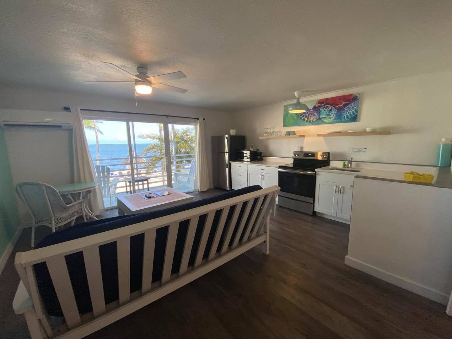 A compact kitchen with a dining area, a ceiling fan, and a view of the ocean.