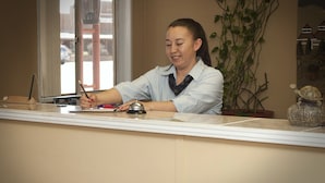 A reception desk with a telephone, a plant, and a welcome sign. - Budget Inn and Suites Colby (Colby)