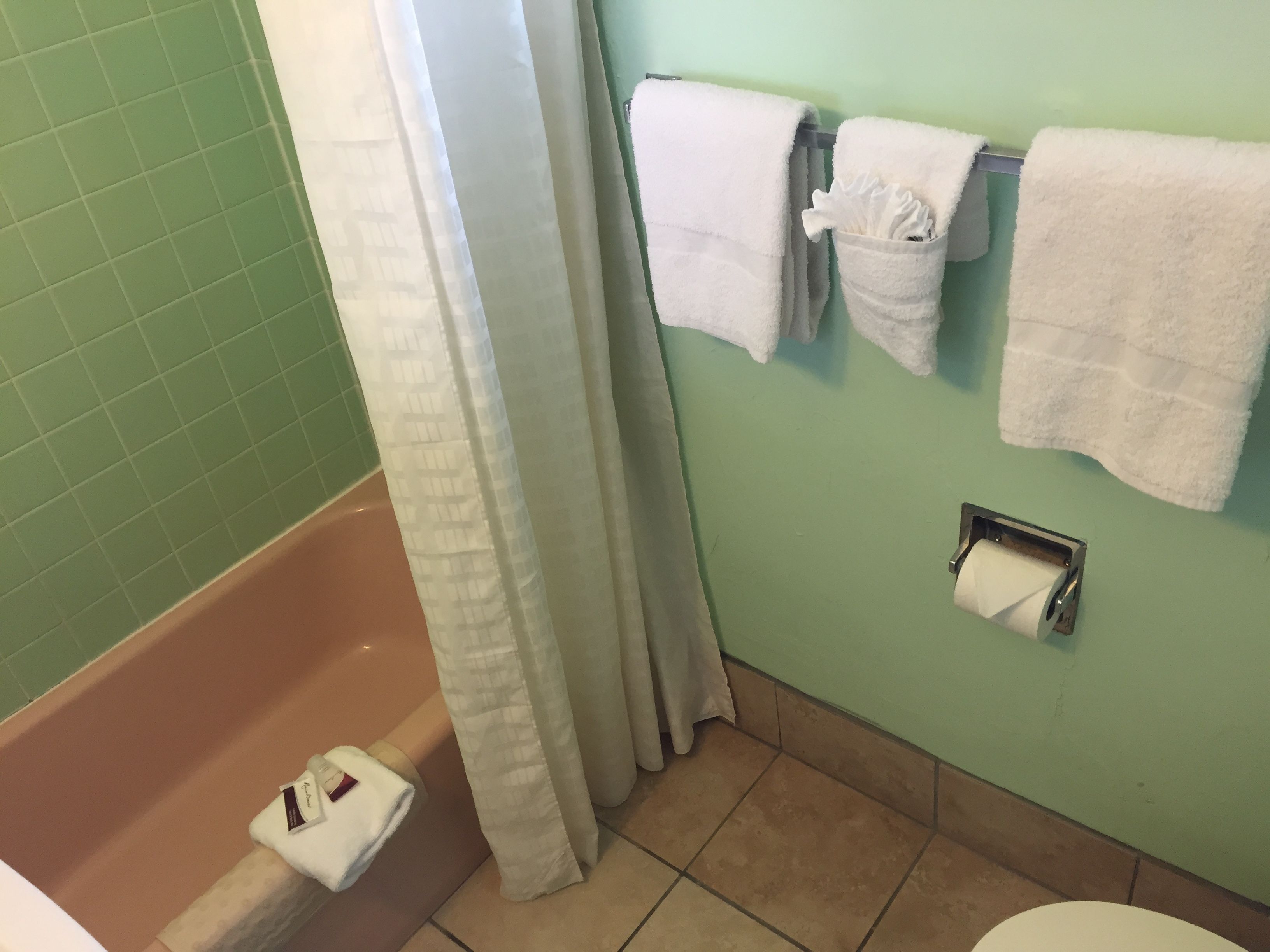 Une salle de bain équipée d’une baignoire, de toilettes et d’un porte-serviettes avec plusieurs serviettes.