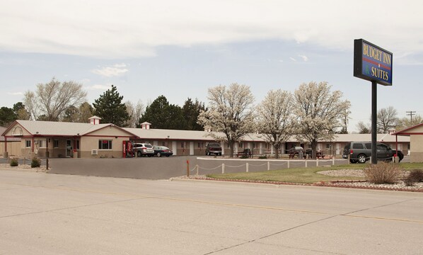 A motel with multiple rooms, a Coca-Cola sign, and a sign for Budget Inn & Suites.