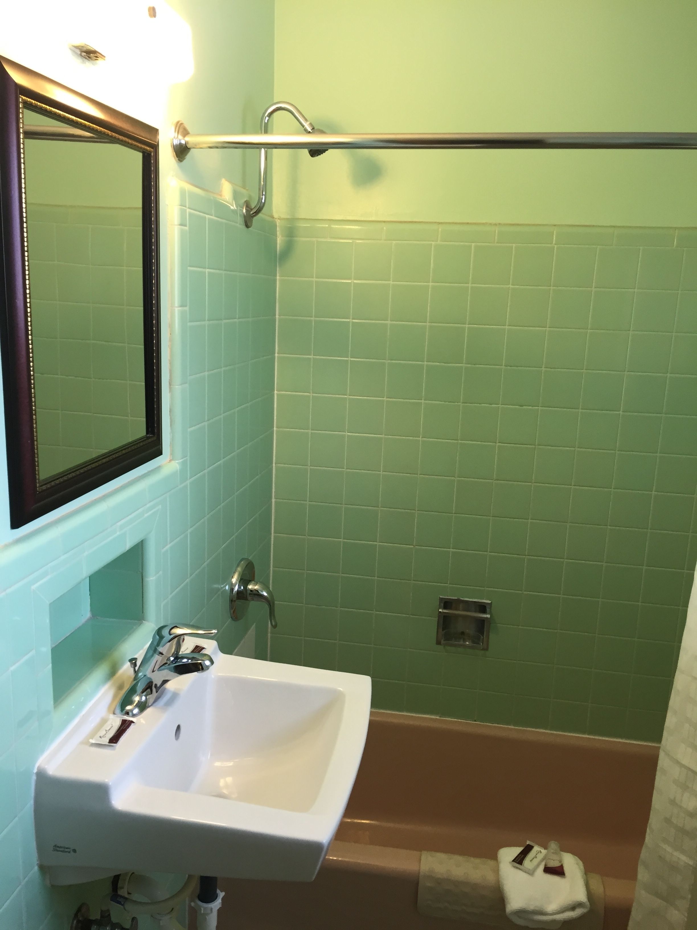 A bathroom with a white sink, a mirror, and a shower area.