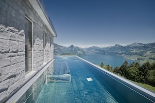 Una piscina al aire libre, sombrillas, sillones reclinables de piscina