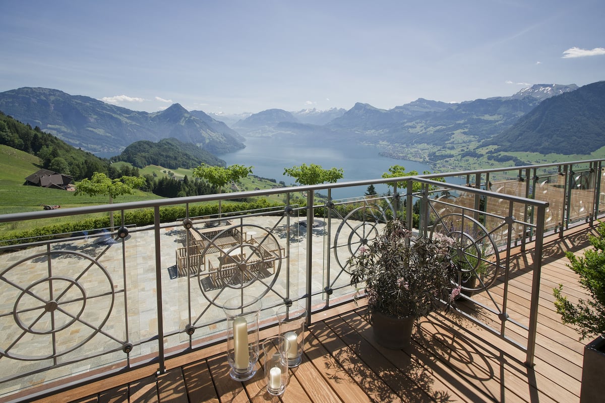 A terrace with a scenic mountain view, a table with chairs, and candles.