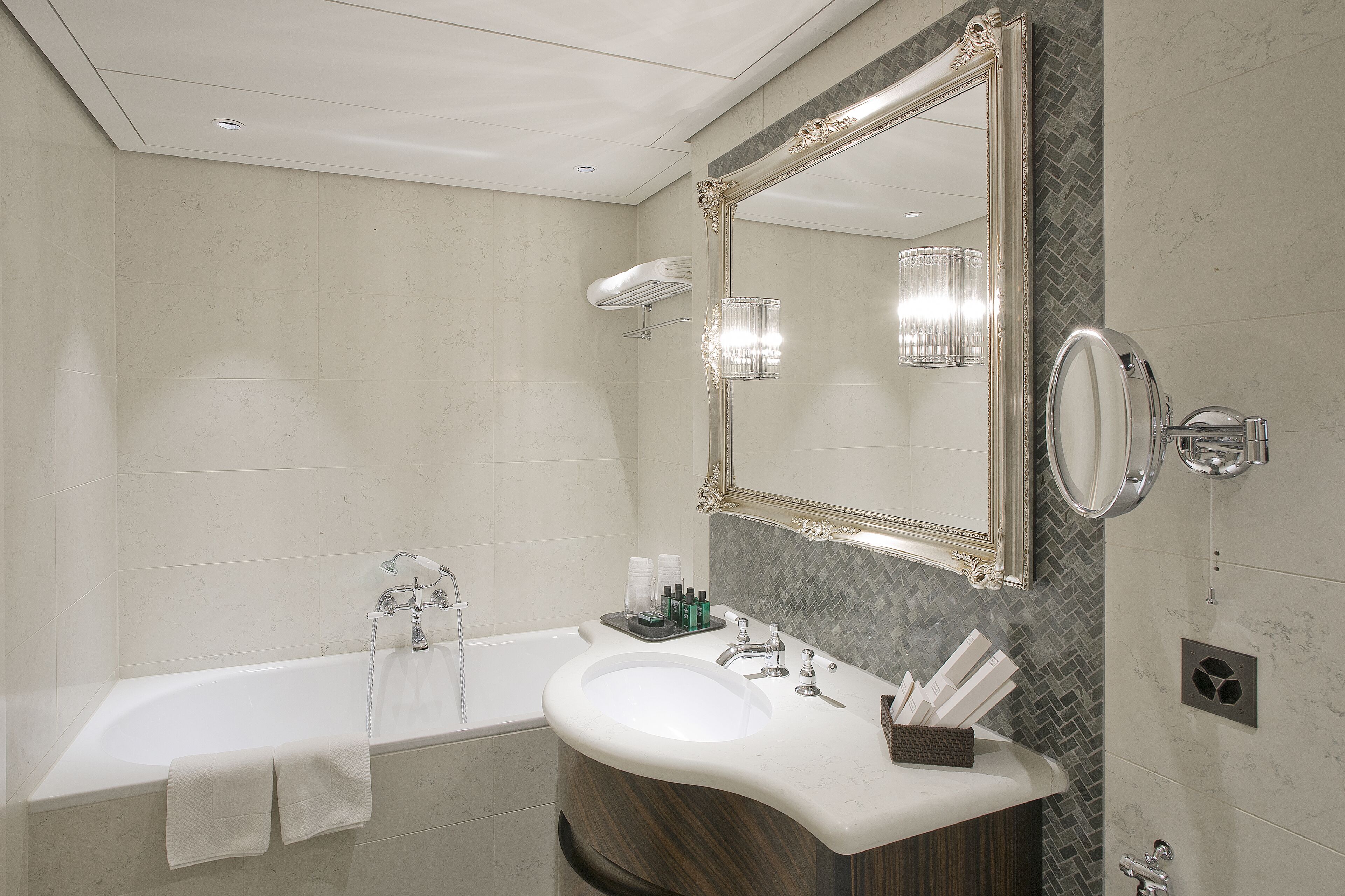 Une salle de bain moderne avec une baignoire, un meuble-lavabo avec un miroir et un espace douche.