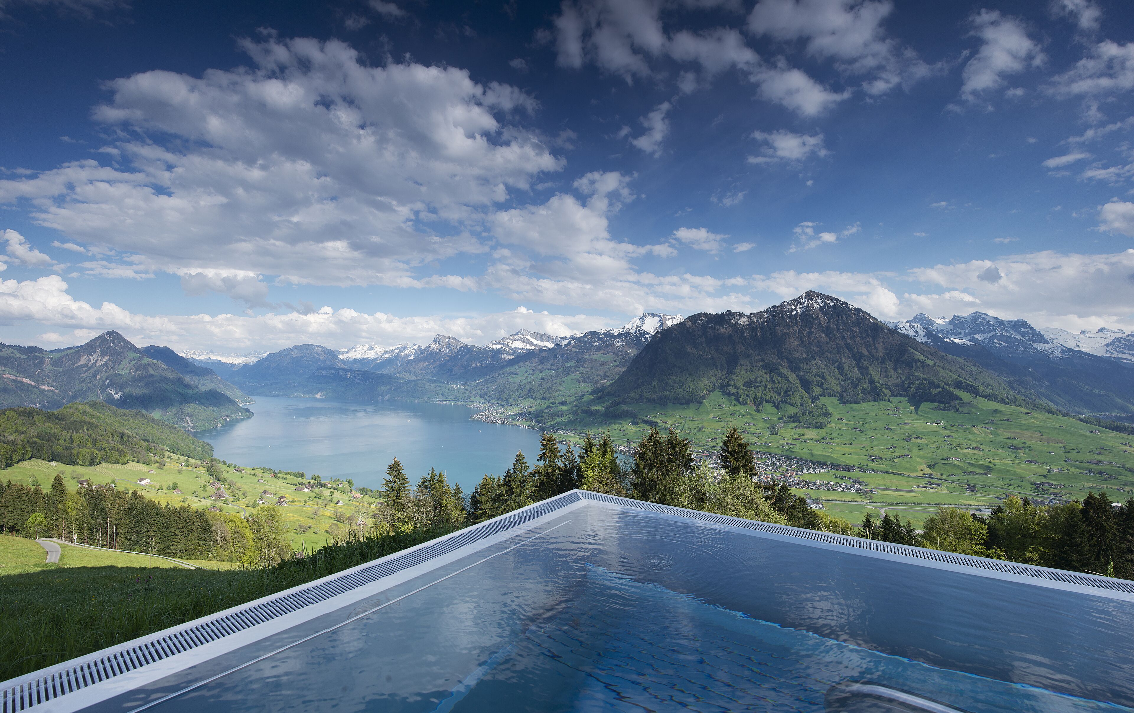 Una piscina con vistas a montañas y un lago.
