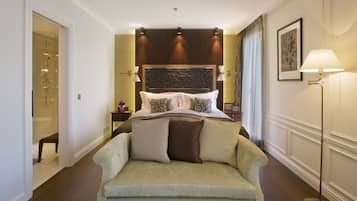 Ein Hotelzimmer mit Bett, Sofa, Nachttisch, Lampe und einem gerahmten Bild an der Wand.
