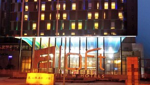 A hotel building with multiple floors, large windows, and a prominent entrance with a sign. - Aloft Zhengzhou Shangjie (Zhengzhou)