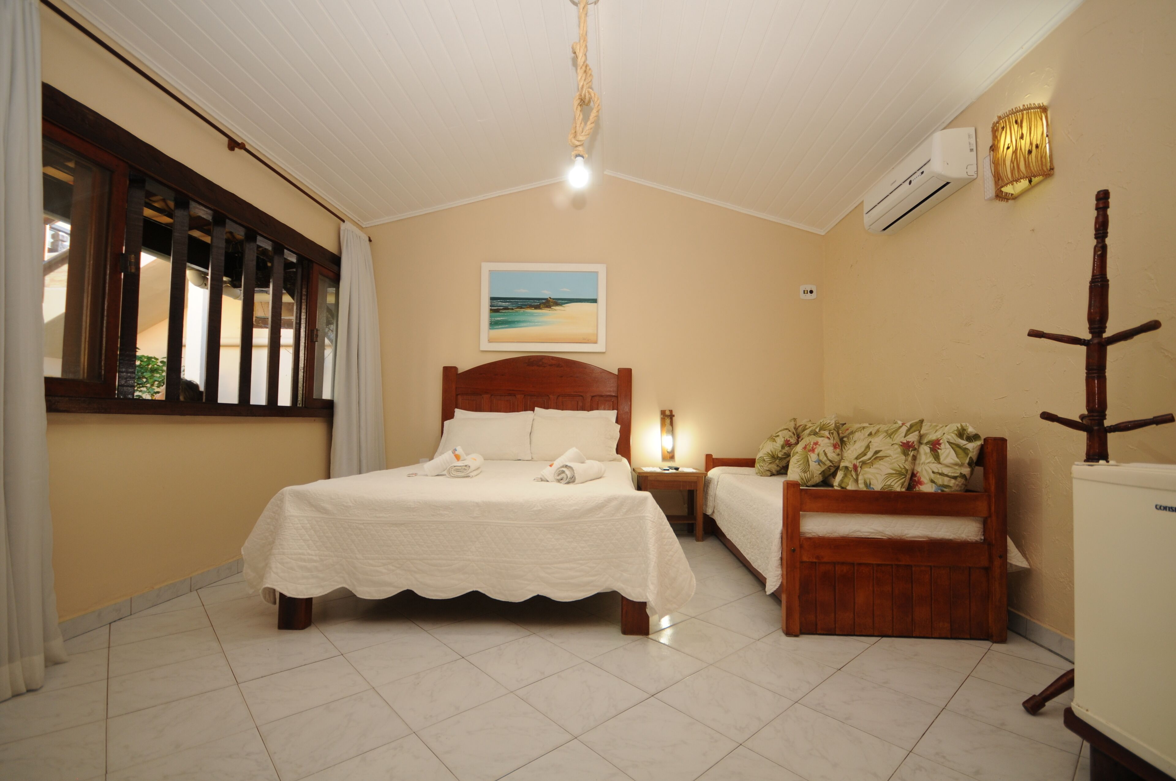 A bedroom with a bed, bedside table, and a small sofa.