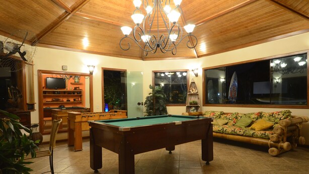 A cozy living room with a pool table, a sofa, and a television. - Pousada Mar e Terra (Búzios)