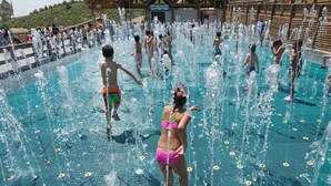 Una piscina con múltiples chorros de agua y gente disfrutando.