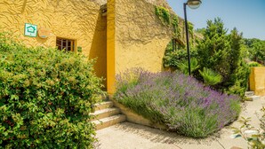 Un edificio amarillo con un arco de piedra, una puerta y un letrero que indica una vivienda.