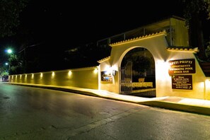 A gated entrance to a residential area with a sign indicating apartments and a swimming pool.