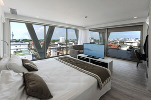 Suite Deluxe, terraza, vistas parciales al mar | Minibar, caja fuerte, escritorio y sistema de insonorización