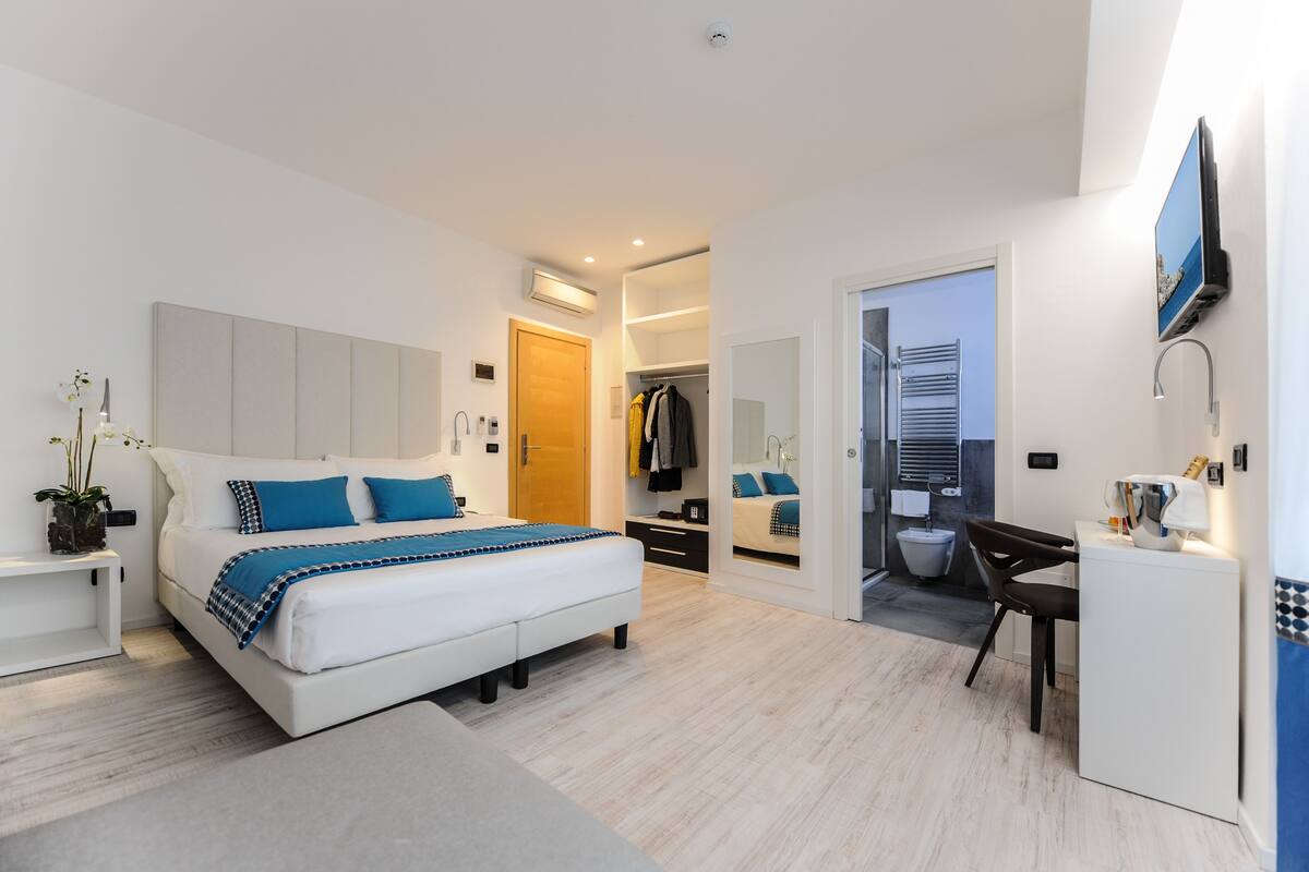 Une chambre à coucher moderne, avec un lit, une table de chevet et un bureau avec une chaise.
