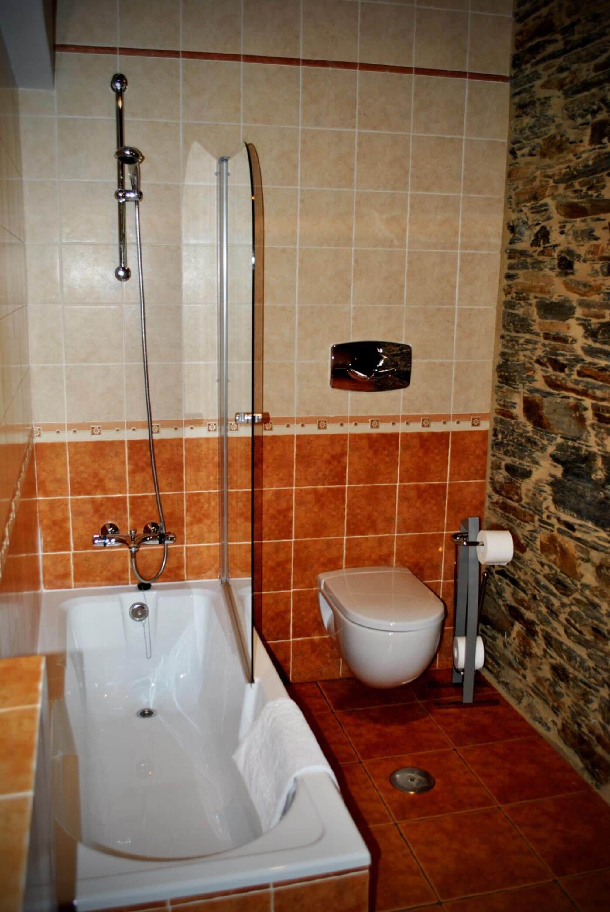 Un baño con bañera, inodoro y ducha.