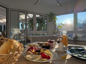 A breakfast setting with a variety of fruits, a glass of orange juice, and a dessert plate. - Hotel Annablick (Strausberg)