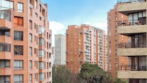 A multi-story residential building with a brick facade, balconies, and a street view.