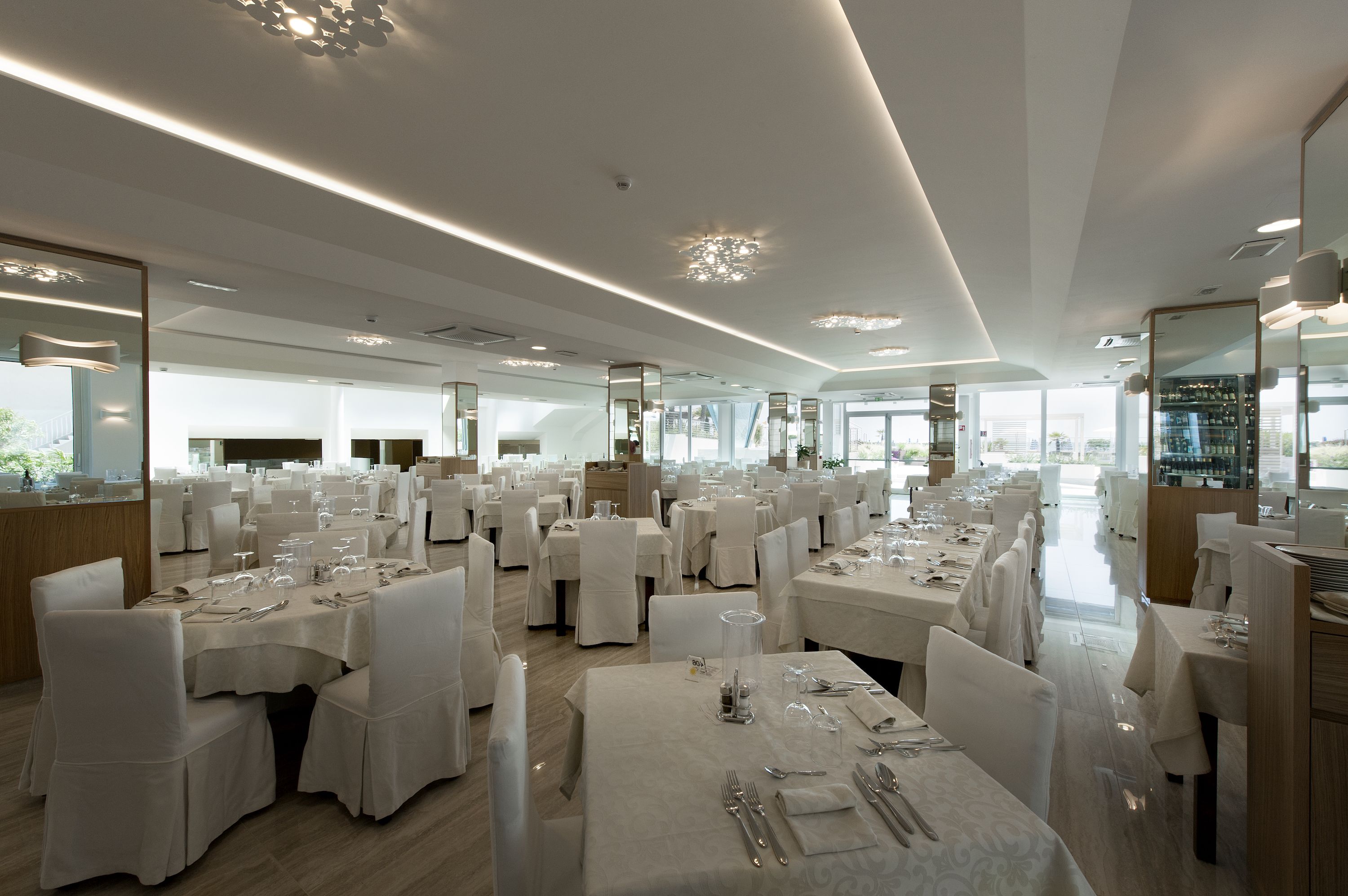 Ein geräumiges Restaurant mit mehreren Essplätzen, großen Fenstern und einem modernen Interieur.