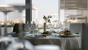 A dining table set for a meal with a view of the cityscape. - Hotel Le Soleil (Jesolo)