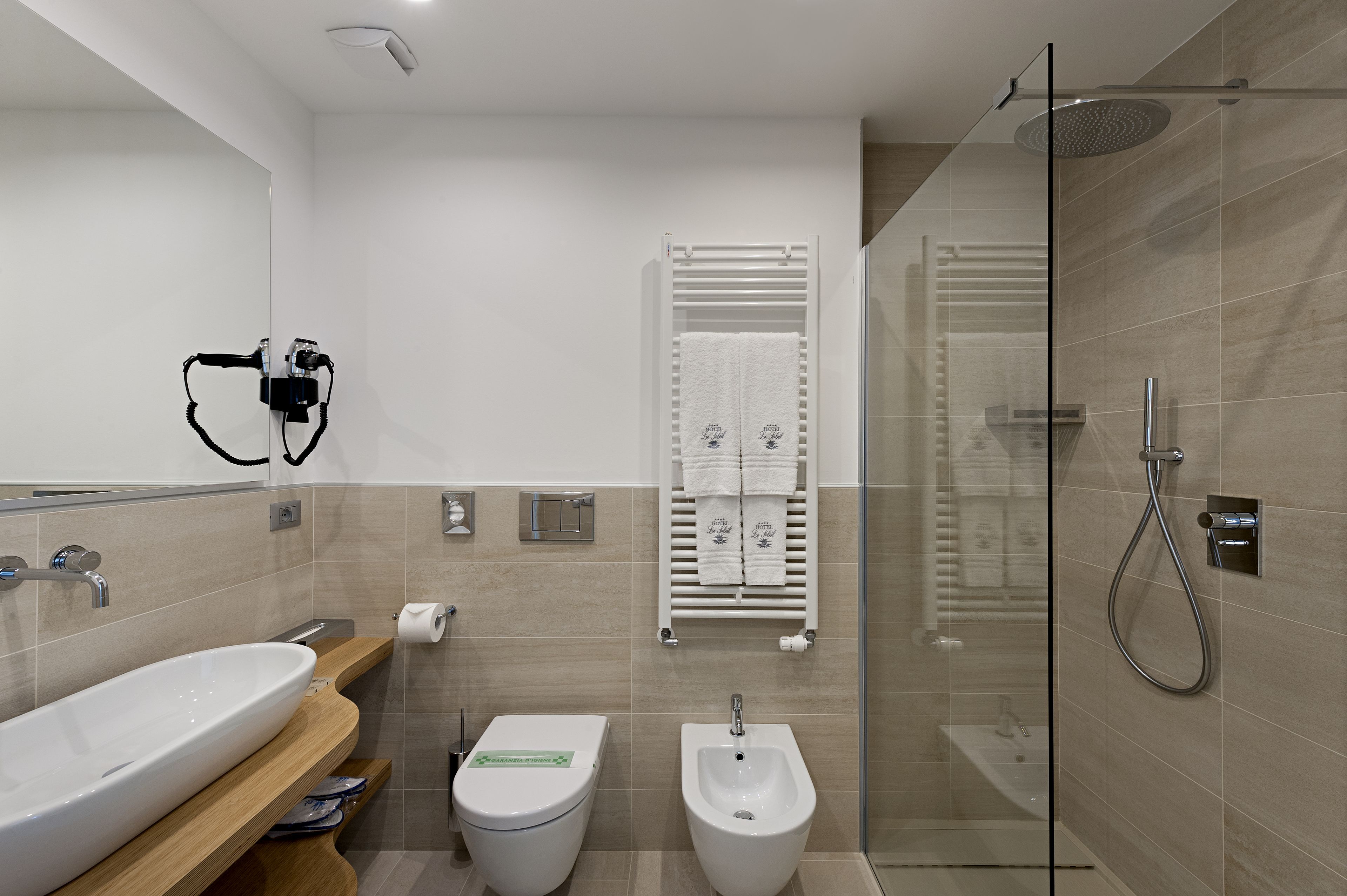 Un baño moderno con un lavamanos grande, un bidé y una ducha.