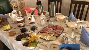 A breakfast buffet with various food items, including bread, cheese, and pastries. - Haus am Markt (Königstein)