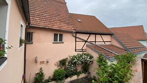 A building with a sloped roof, a small window, and a balcony with railings. - Haus am Markt (Königstein)