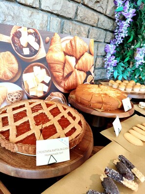 A display of various baked goods including pies, croissants, and cookies.