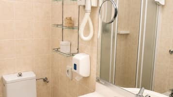 Une salle de bain équipée d’un WC, d’un lavabo, d’un miroir et d’un porte-serviettes.