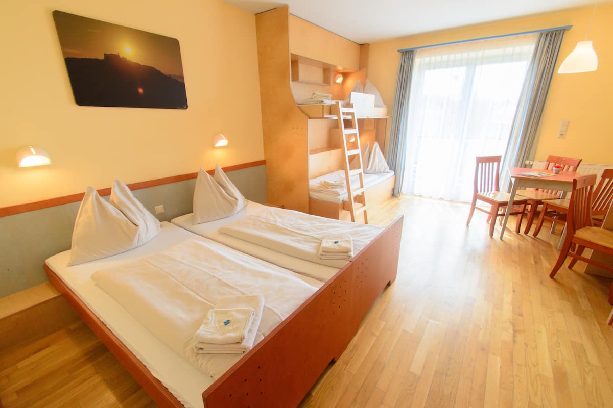Een hotelkamer met twee bedden, een bureau en een stoel.