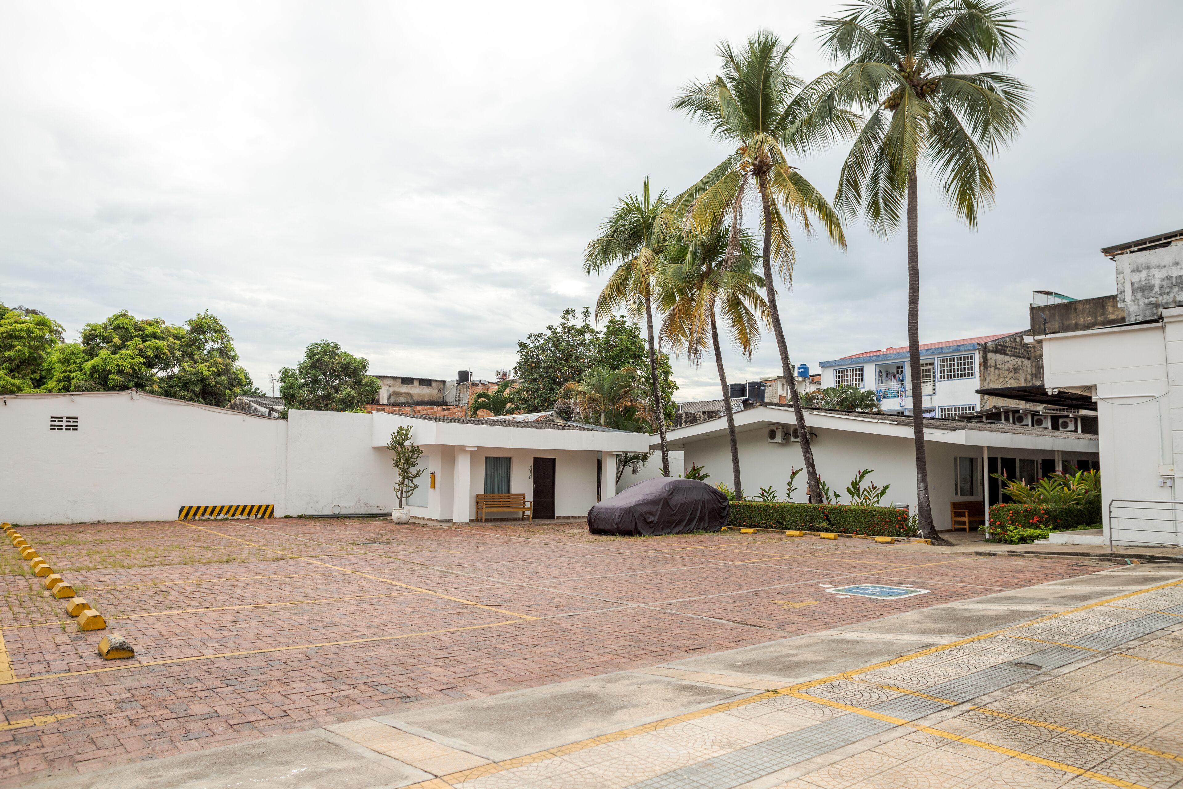 A courtyard with a paved area, a covered seating area, and a building with a white exterior.