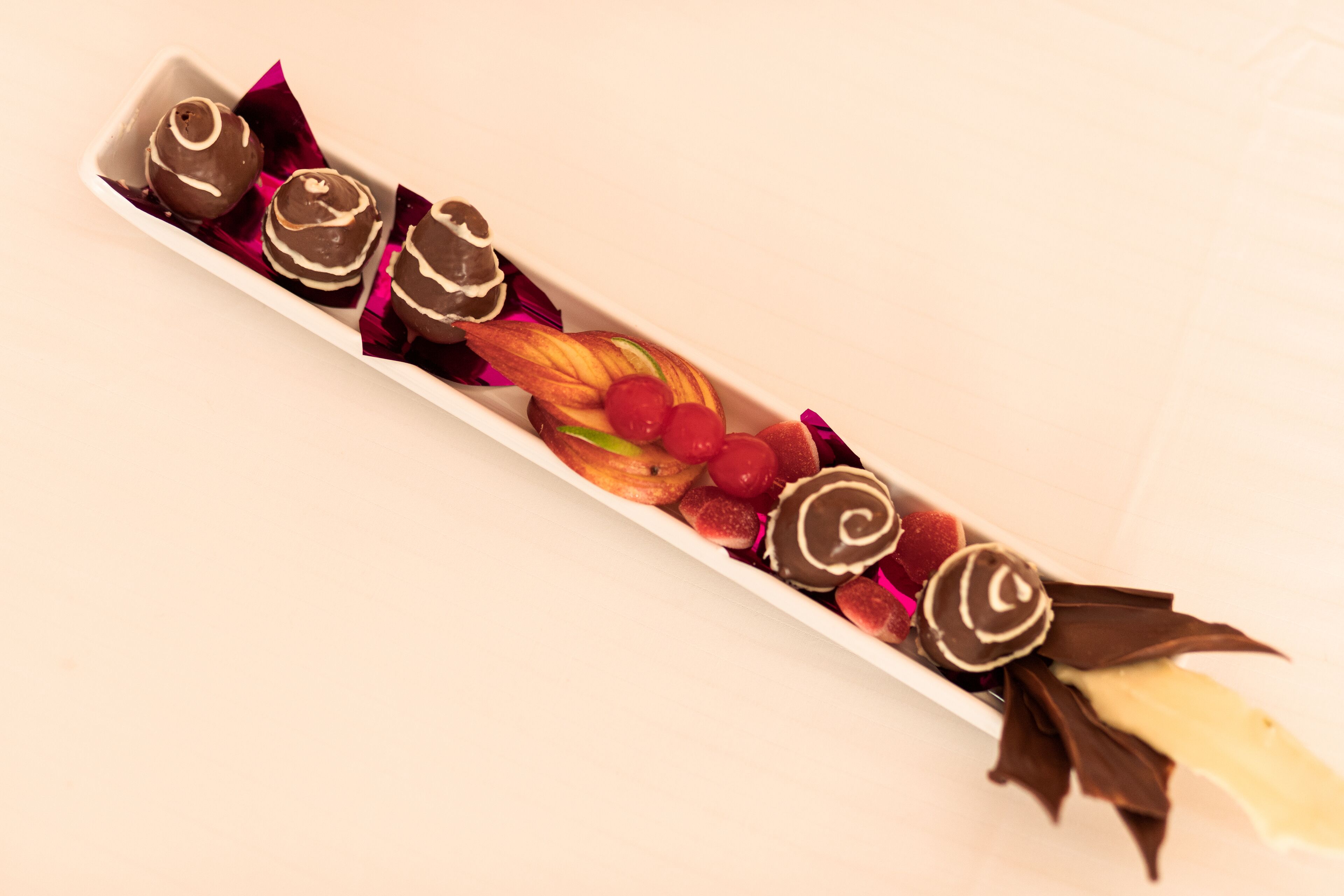 A tray of assorted chocolates and fruits.