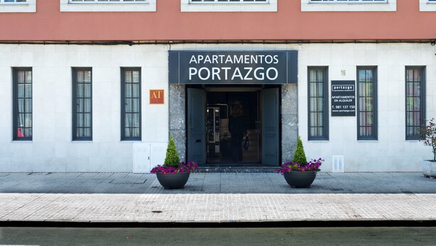 A building with multiple windows and a sign that reads "APARTAMENTOS PORTAZGO". - Apartamentos Portazgo (A Coruña)