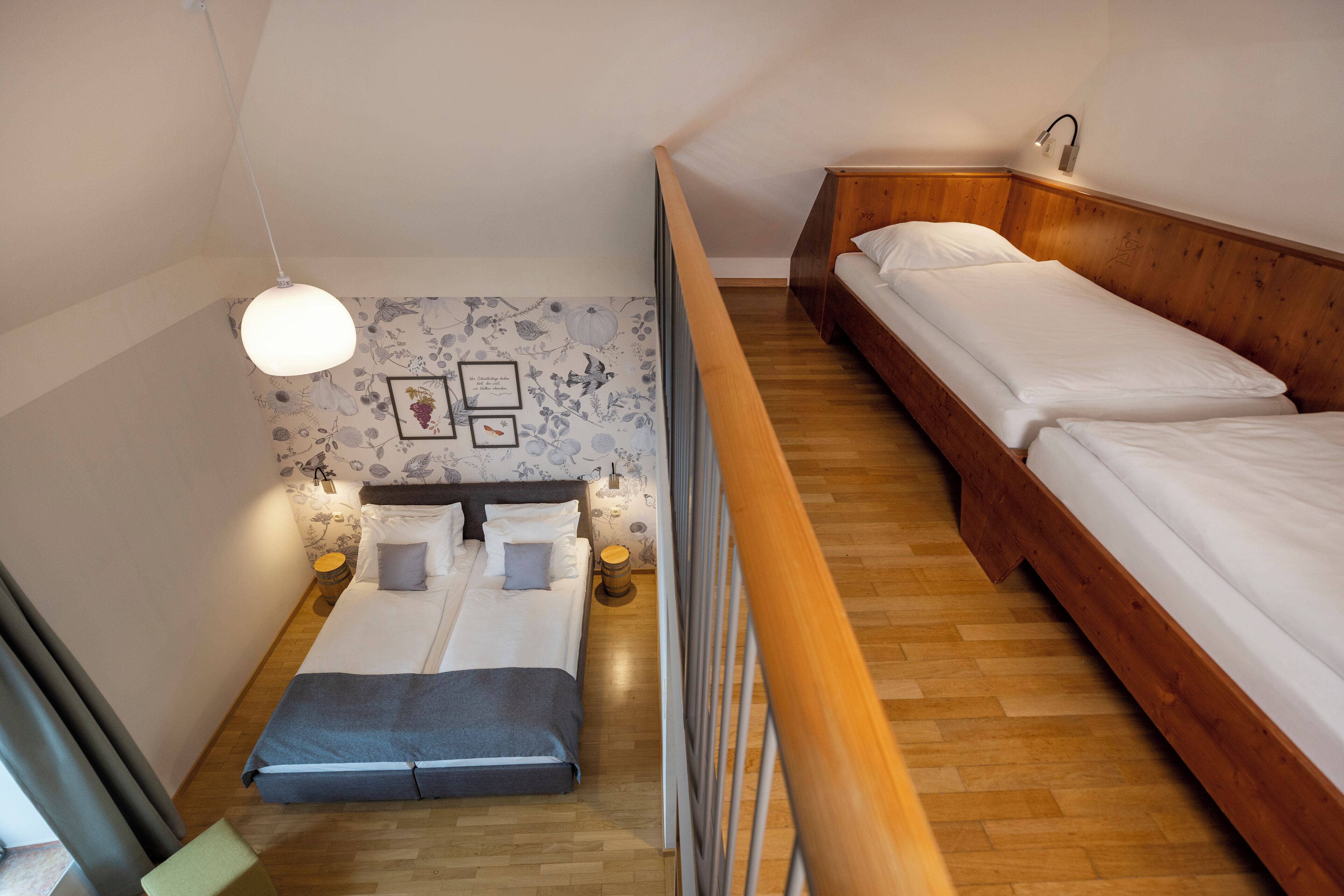 A bedroom with a loft bed, a small seating area, and a wooden floor.
