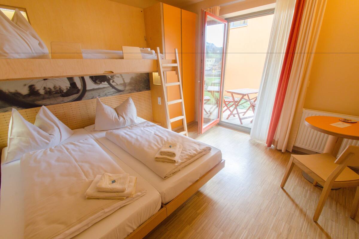 Una habitación de hotel con cama, escritorio y balcón.