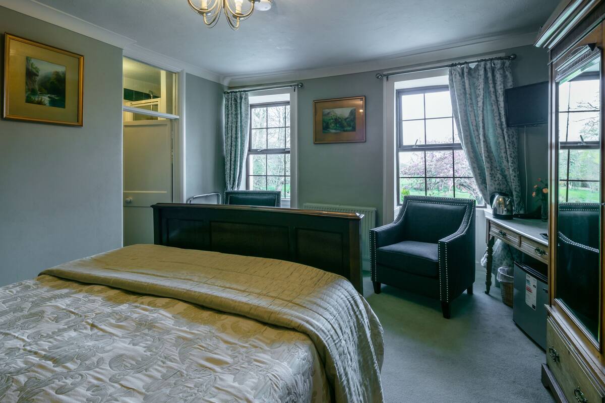 Une chambre à coucher avec un grand lit, un bureau, une chaise et une commode.