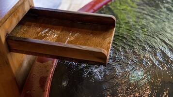 A wooden tray over a water feature with a reflective surface.