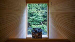 Interior de madera con una ventana que muestra una vista del bosque.