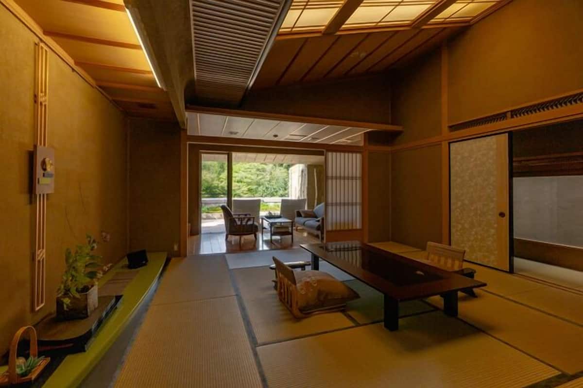 A traditional Japanese-style room with tatami flooring, a low table, and sliding doors.