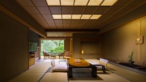 Una habitación tradicional japonesa con suelo de tatami, una mesa baja y puertas correderas shoji.