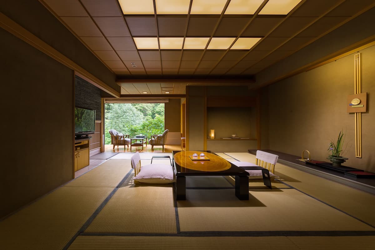 A traditional Japanese-style room with tatami flooring, a low table, and shoji screens.