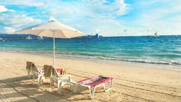 On the beach, white sand, sun loungers, beach umbrellas
