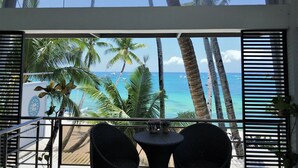 Un balcón con vista al océano y palmeras.