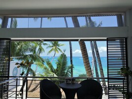 Un balcón con vista al océano y palmeras.
